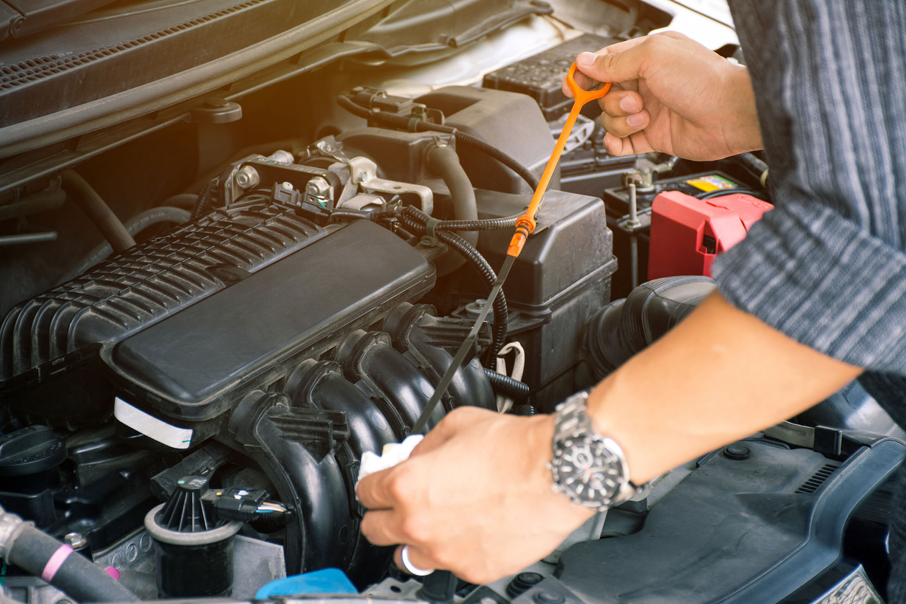 auto mechanic worker hands checking the car engine oil